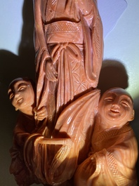 A Chinese carved red coral group of a lady with two boys, 19/20th C.