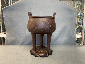 A Chinese inlaid bronze tripod censer on wooden stand, Ming
