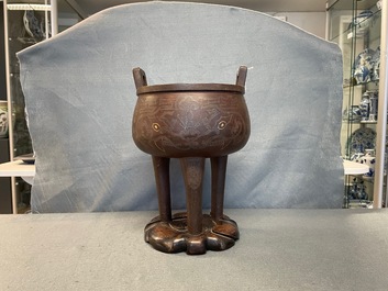 A Chinese inlaid bronze tripod censer on wooden stand, Ming