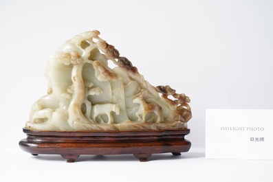 A Chinese mottled celadon and brown jade 'Eight horses of Mu Wang' carving, Qing