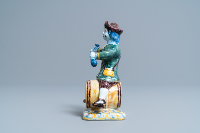 A polychrome Dutch Delft figure of a wine drinker on a barrel inscribed 'Rood Wyn', 18th C.