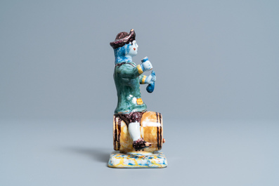 A polychrome Dutch Delft figure of a wine drinker on a barrel inscribed 'Rood Wyn', 18th C.