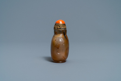 A Chinese agate snuff bottle with coral and gilt brass stopper, 19th C.