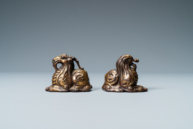 Deux poids de rouleaux en bronze dor&eacute; et laqu&eacute; en forme d'animaux mythiques, Chine, Ming