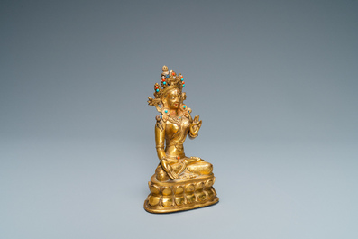 A Sino-Tibetan coral- and turquoise-inlaid gilt bronze figure of Tara, 18th C.