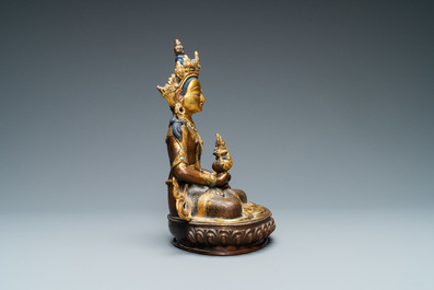 Een Nepalese met koraal en turkoois ingelegde deels vergulde koperen figuur van Boeddha, 19/20e eeuw