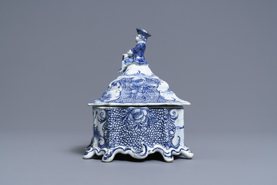 A Dutch Delft blue and white tobacco box and cover with a boy near a barrel, 18th C.