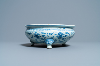 Een Chinese blauw-witte driepotige wierookbrander met floraal decor, Ming
