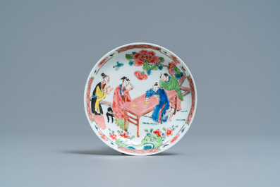 A Chinese famille rose 'tea scene' cup and saucer, Yongzheng/Qianlong