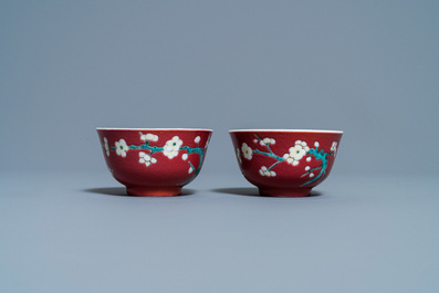 A pair of Chinese famille rose ruby-ground cups and saucers, Yongzheng