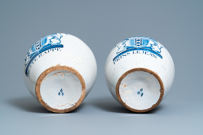 A pair of large Dutch Delft blue and white tobacco jars with the arms of Amsterdam, 18th C.