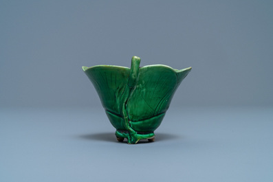 A Chinese 'egg and spinach'-glazed lotus cup and saucer with applied design, Kangxi