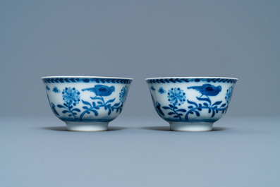 A pair of Chinese blue and white 'Caritas' cups and saucers, Kangxi/Yongzheng