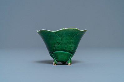 A Chinese 'egg and spinach'-glazed lotus cup and saucer with applied design, Kangxi