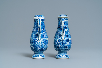 A pair of Chinese blue and white ewers and covers with floral design, Kangxi