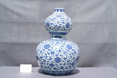 A large Chinese blue and white double gourd vase with floral scrolls, 19/20th C.