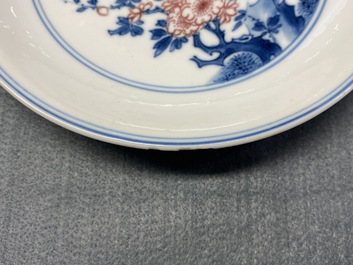 A Chinese blue, white and copper-red saucer dish with floral design, Kangxi