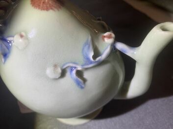 Een Chinese perzikvormige 'cadogan' theepot met reli&euml;fdecor in blauw en koperrood op celadon fond, 19e eeuw