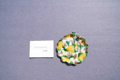 A Chinese 'egg and spinach'-glazed lotus cup and saucer with applied design, Kangxi