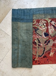 A large Chinese horizontal embroidered red-ground textile panel, 19th C.