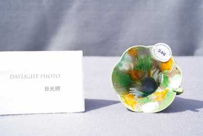 A Chinese 'egg and spinach'-glazed lotus cup and saucer with applied design, Kangxi