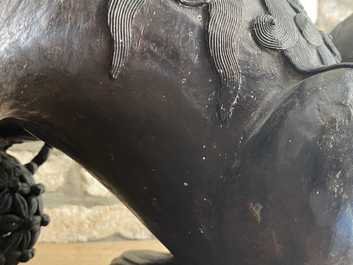 A pair of large Chinese bronze models of Buddhist lions, Ming