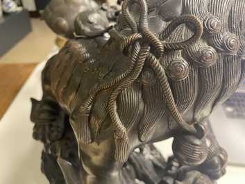 Un mod&egrave;le d'un lion bouddhiste en bronze sur socle en bois sculpt&eacute;, Chine, 18&egrave;me