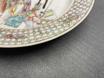 A Chinese famille rose plate with figures in an interior, Yongzheng