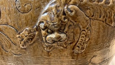 Een grote Chinese bruin-geglazuurde martavaan met reli&euml;fdecor van boeddhistische leeuwen, Ming