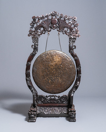 A Chinese bronze gong set in a carved wooden stand, 19th C.