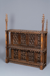 A carved oak shelf with pinnacles and stylised flowers and carved panels, 15th C. and later