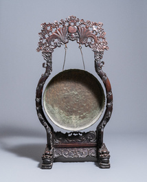 A Chinese bronze gong set in a carved wooden stand, 19th C.