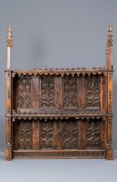 A carved oak shelf with pinnacles and stylised flowers and carved panels, 15th C. and later