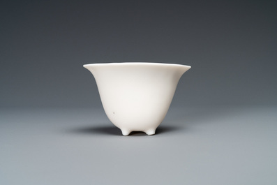 A Chinese Dehua blanc de Chine tripod wine cup with inscription, Kangxi