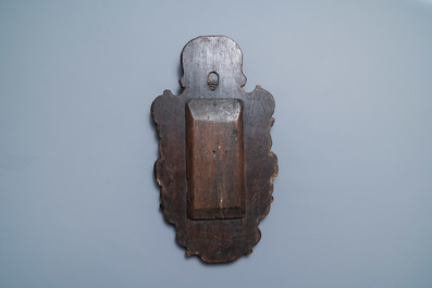 A patinated wooden niche with a Madonna with child flanked by cherub heads, 18th C.