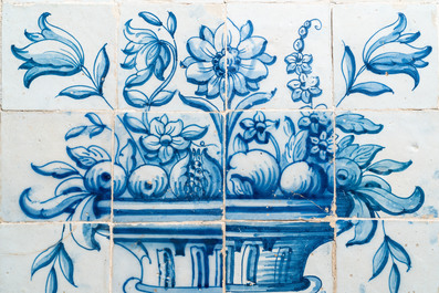 Een blauw-wit Portugees tegeltableau met een urne gevuld met bloemen en fruit, 18e eeuw