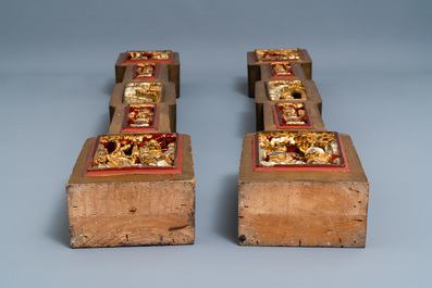 A Chinese gilded wood carving on matching pillars, 19th C.