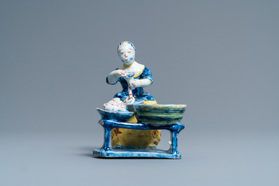 Une rare statue d'une bouch&egrave;re pr&eacute;parant les saucisses en fa&iuml;ence polychrome de Delft, 18&egrave;me