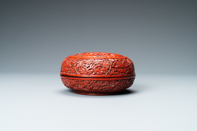 A Chinese round cinnabar lacquer box and cover with two scholars at a table, 18/19th C.