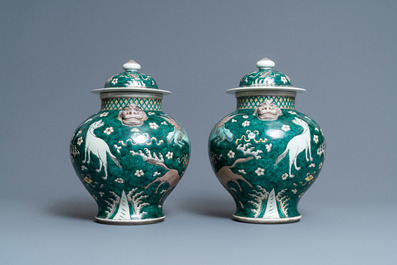 A pair of Chinese famille verte 'mythical animals' vases and covers, 19th C.