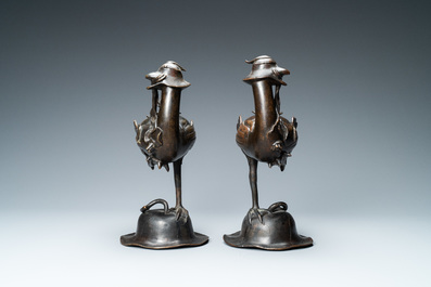 A pair of Chinese bronze censers modelled as ducks on a lotus flower, late Ming/early Qing