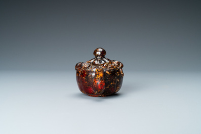 A Chinese carved amber teapot and cover on wooden 'lotus' stand, 19th C.
