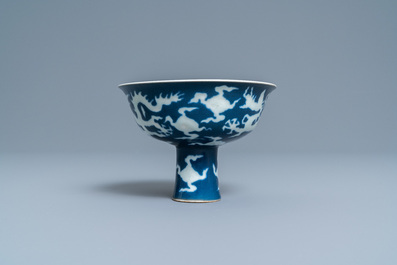 Un bol sur piedouche en porcelaine de Chine &agrave; d&eacute;cor incis&eacute; d'un dragon sur fond bleu, marque de Xuande, R&eacute;publique
