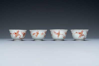 Four Chinese iron-red and gilt cups and saucers with figures near a table, Kangxi