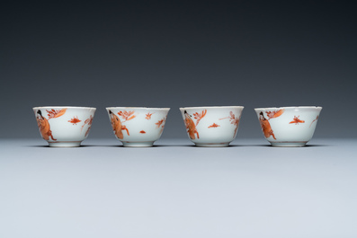 Vier Chinese ijzerrode en vergulde koppen en schotels met figuren bij een tafel, Kangxi