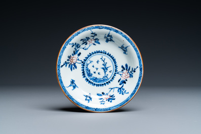 A Chinese blue, white and copper-red cup and saucer, Kangxi