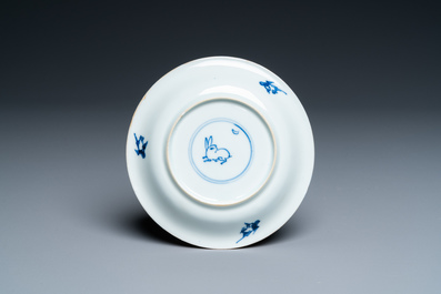 A Chinese blue, white and copper-red cup and saucer, Kangxi