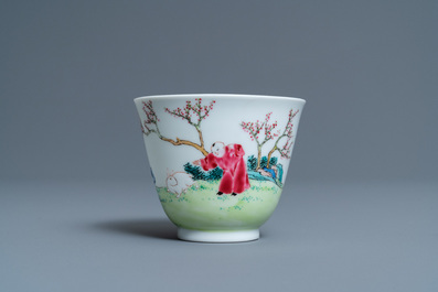 A Chinese famille rose cup and saucer with ladies and a boy playing with a rabbit, Yongzheng