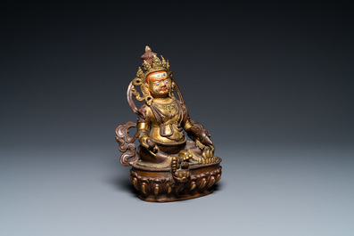 A Sino-Tibetan partly gilt bronze figure of Jambhala with inscriptions on the back, 19th C.