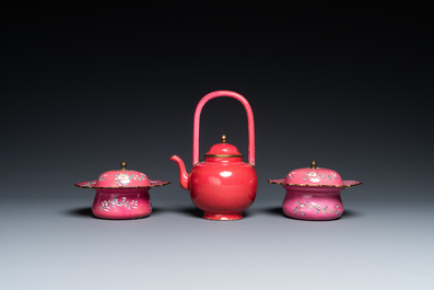 Une th&eacute;i&egrave;re et deux bols couverts en &eacute;maux de Canton au fond rouge de rubis, Chine, Qianlong/Jiaqing